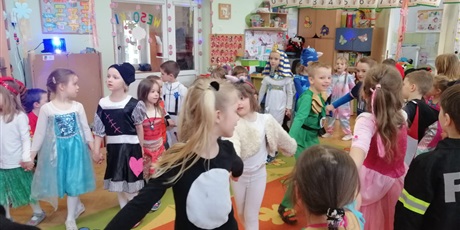 Powiększ grafikę: Przedszkolaki w kolorowych strojach bajkowych tańczą na sali przedszkolnej