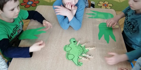 Powiększ grafikę: dzieci z Wesołków grają w zabawy matematyczne bawiąc się dinozaurami