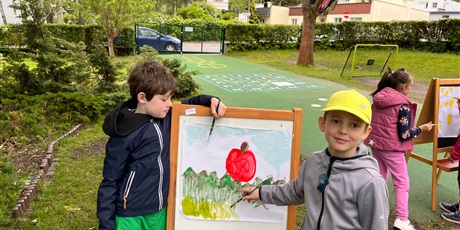 Powiększ grafikę: Dwaj chłopcy z Pracusiów malują w ogrodzie na sztalugach