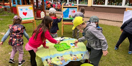 Powiększ grafikę: Dzieci malują na sztalugach w ogrodzie przedszkolnym