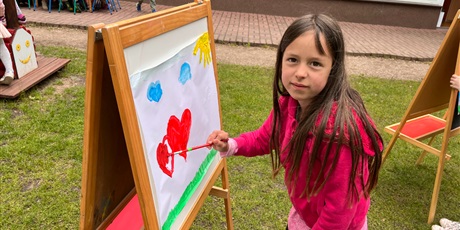 Powiększ grafikę: Dziewczynka wiktoria maluje obraz na sztaludze w ogrodzie