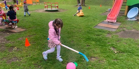 Powiększ grafikę: Dziewczynka gra balonem w ogrodzie